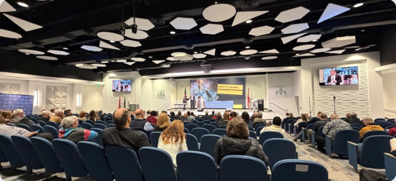 Audience seated at an Orion Media conference presentation
